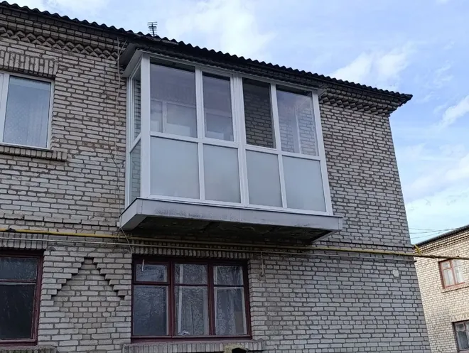 Балкон із білим ПВХ-заскленням і матовими нижніми панелями