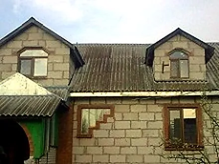 Вікна у будинку з мансардою і фігурними фронтонами